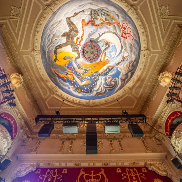 View of the King's Theatre ornate ceiling with a colourful circular mural, surrounded by gold decorative elements and red velvet balcony seats.